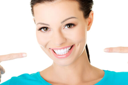 Woman smiling and pointing at her teeth