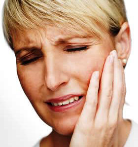 Woman holding her jaw in pain. 